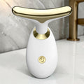 Dispositivo de masaje facial sónico zafiropulse PERENNE Sonic Lift en color blanco y dorado para reafirmar la piel